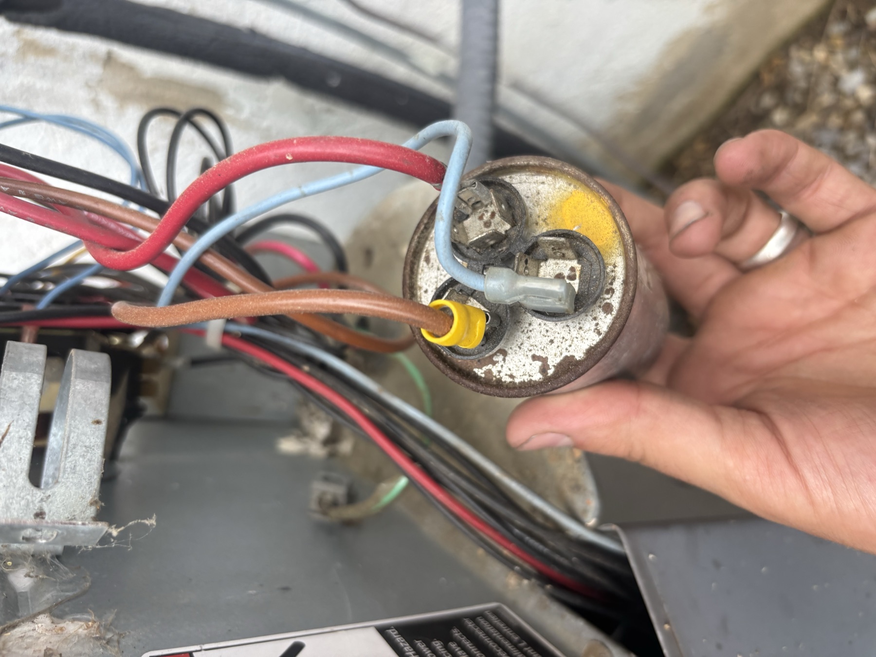 Capacitor wiring repair closeup during AC service.