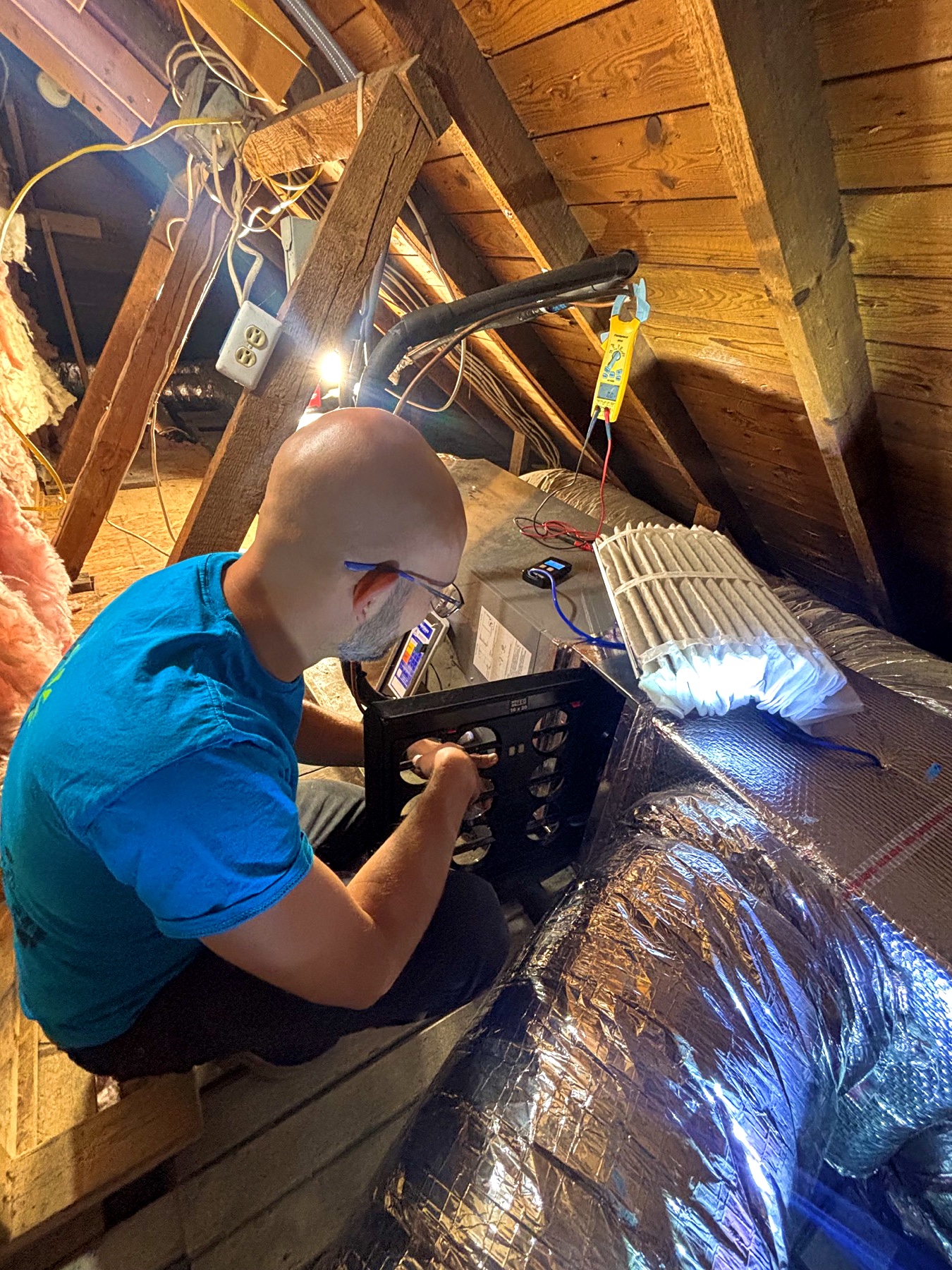 Jacob Myers using a TrueFlow grid to measure HVAC airflow in an older Roanoke-area home.