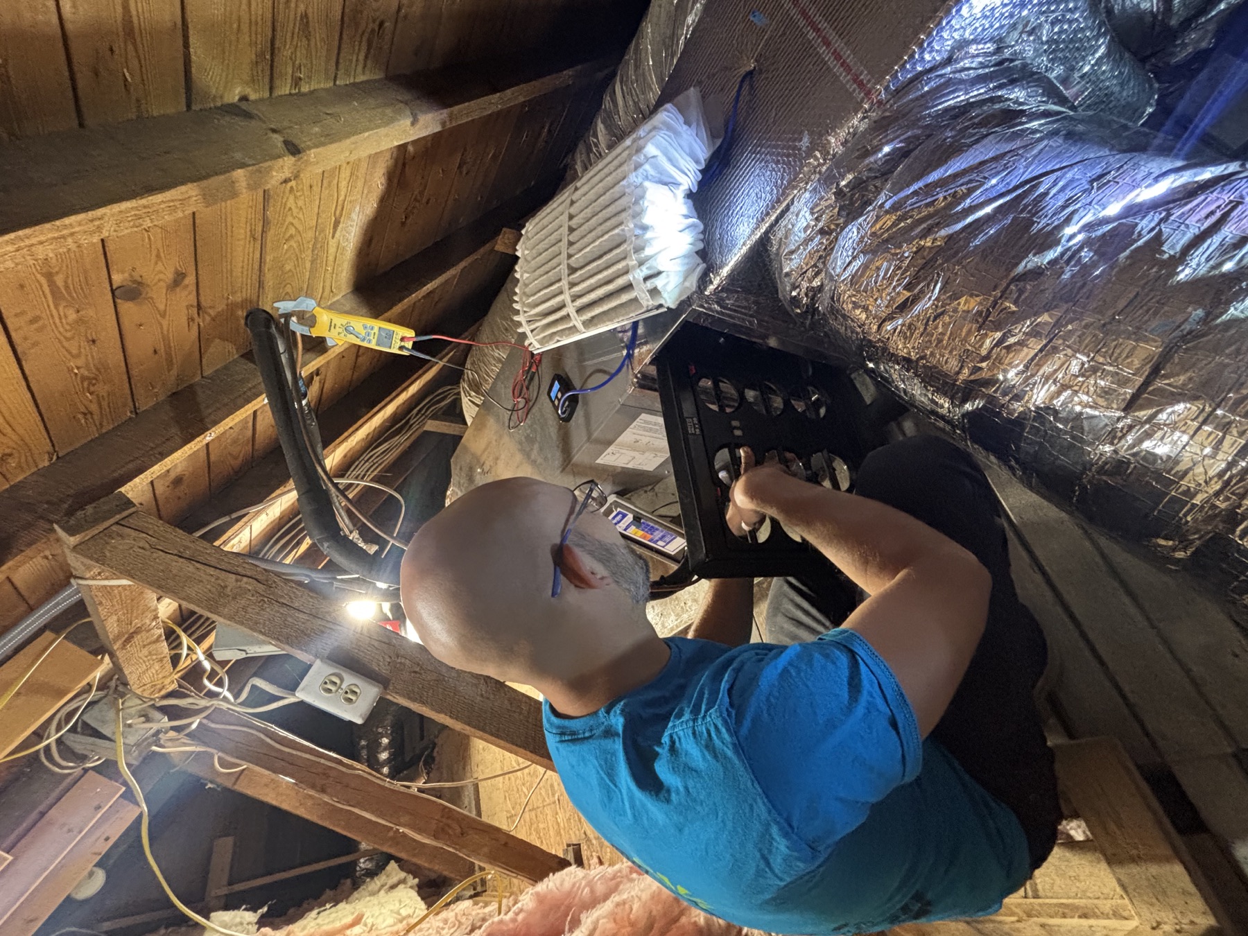 Jacob Myers using a TrueFlow grid to measure HVAC airflow in an older Roanoke-area home.