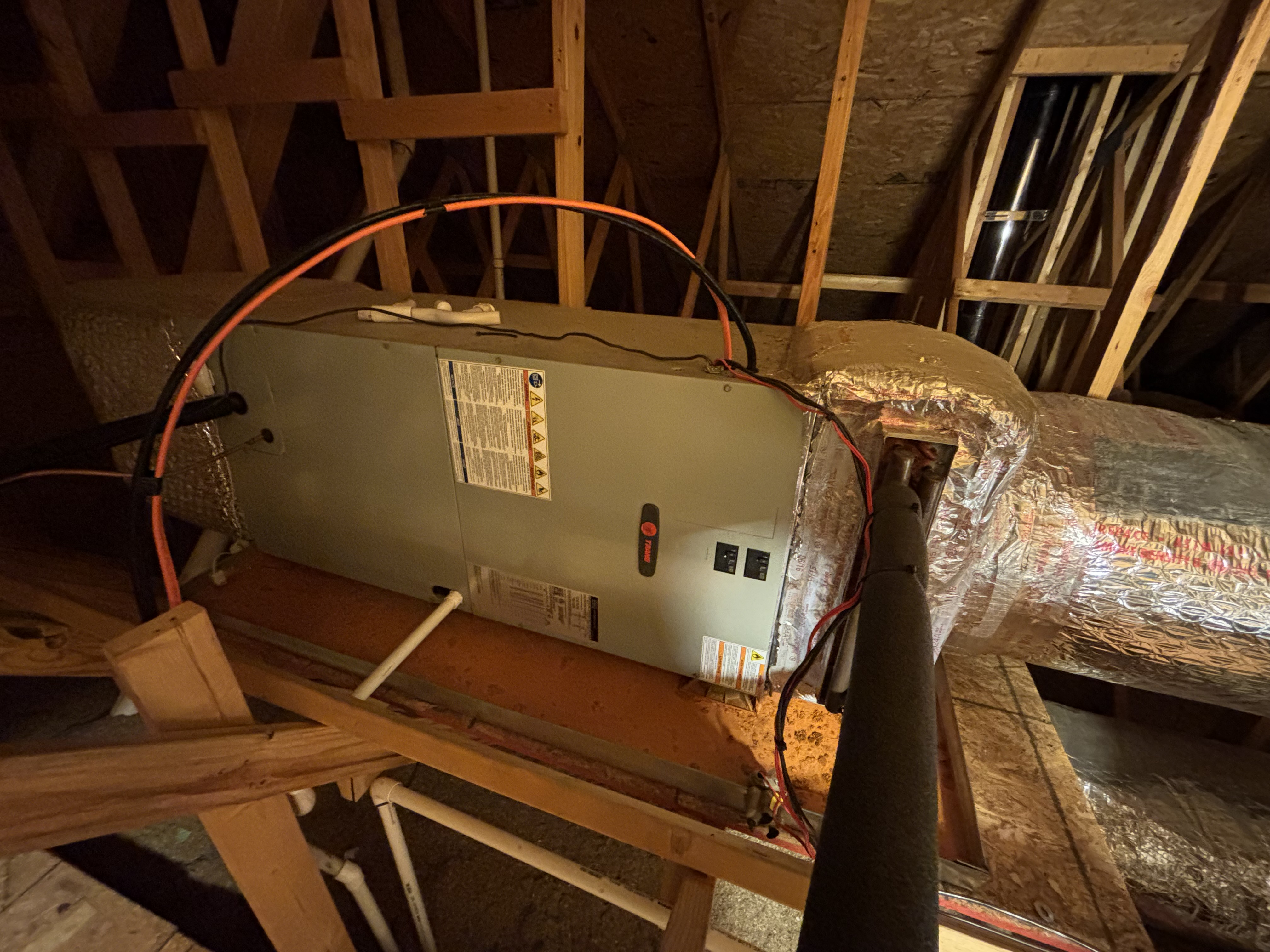 Attic air handler and ductwork installation detail in framed construction space.