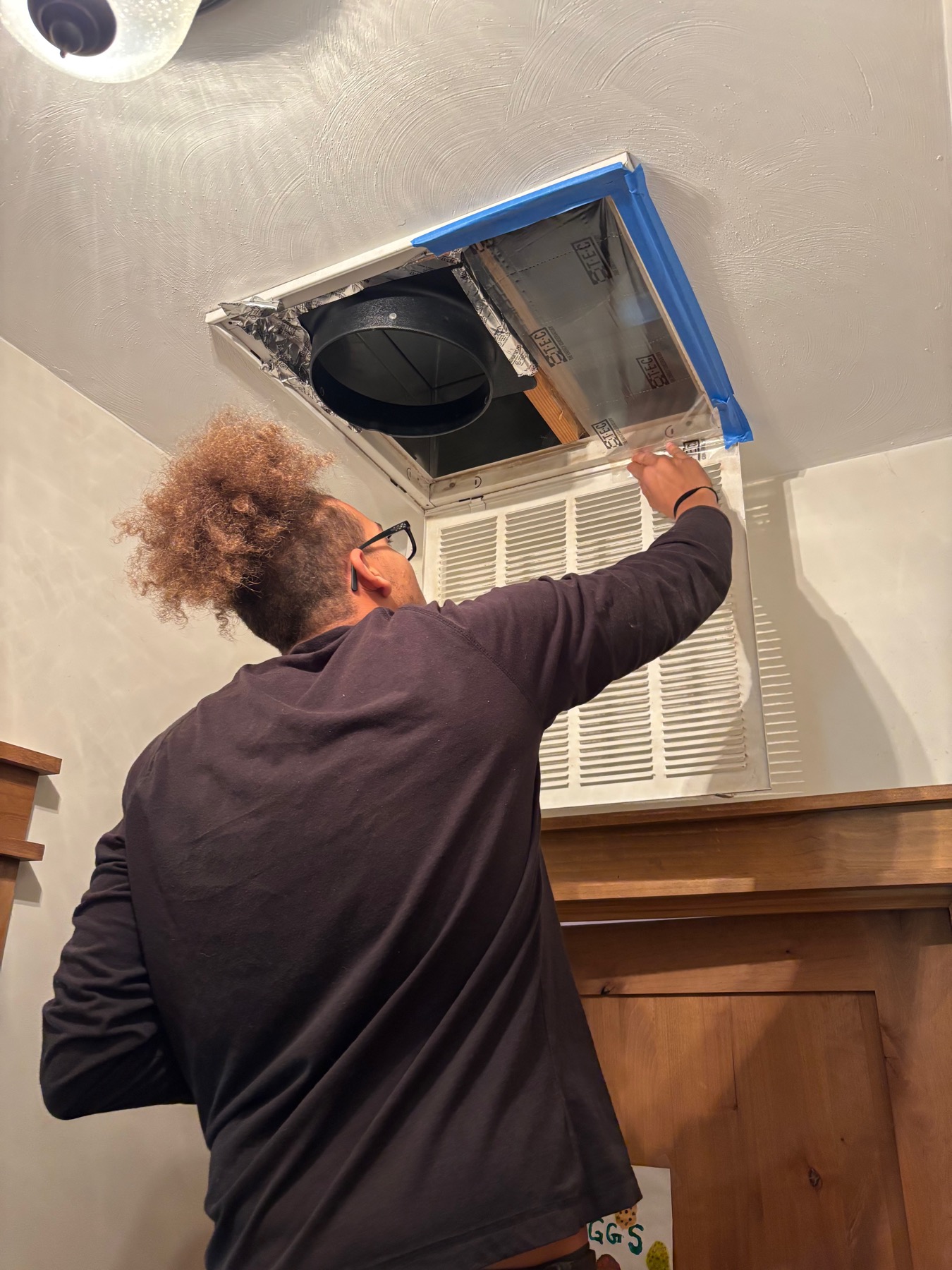 Indoor ductless system opened for seasonal HVAC service.